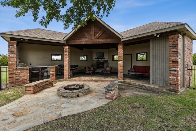 3060 Anna Cade Cir, Rockwall, TX 75087 - rear view of property with a patio area, roof with shingles, an outdoor living space with a fire pit, and brick siding