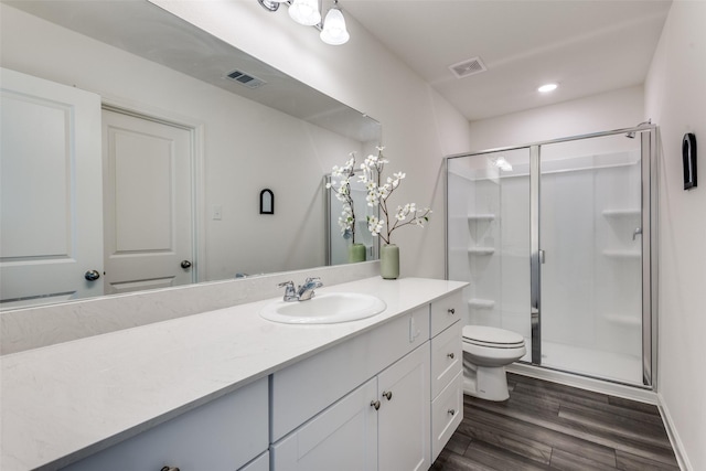 2115 Revere Dr, Princeton, TX 75407 - bathroom with a stall shower, vanity, toilet, wood finished floors, and recessed lighting