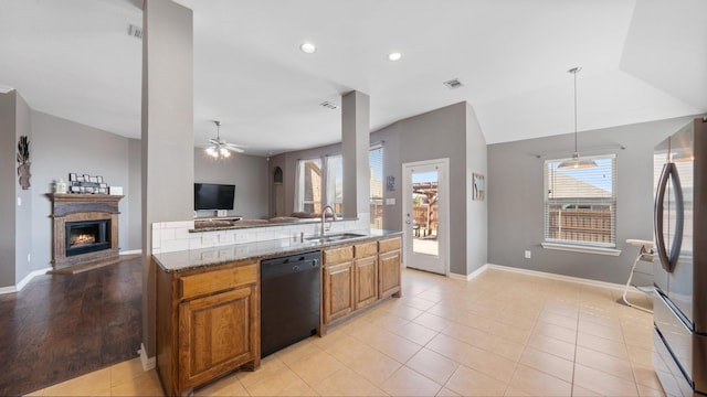 109 Harvest Way, Crandall, TX 75114 - kitchen featuring dishwasher, open floor plan, a sink, a warm lit fireplace, and freestanding refrigerator