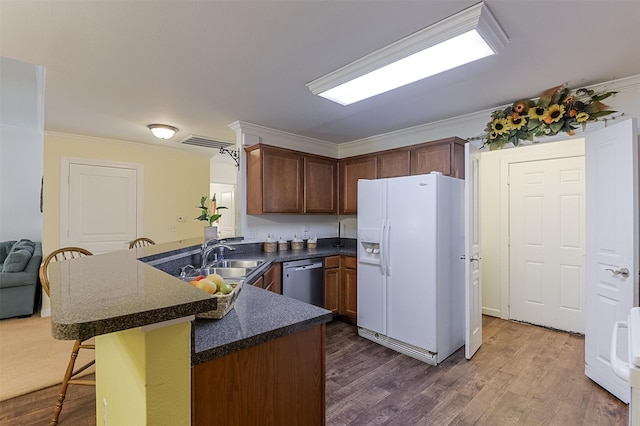819 Earhart Ave, Grand Prairie, TX 75051 - kitchen featuring white fridge with ice dispenser, a sink, a peninsula, dishwasher, and a kitchen bar