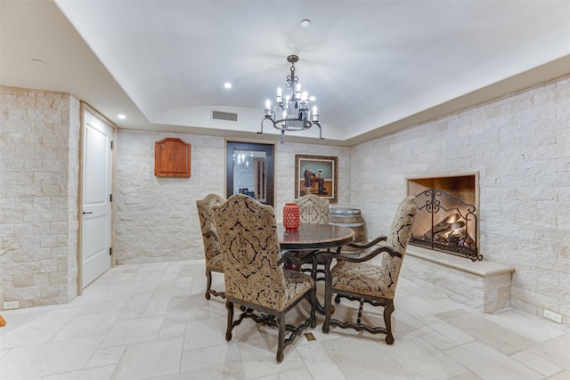 dining room featuring recessed lighting, a chandelier, vaulted ceiling, and light stone finish flooring