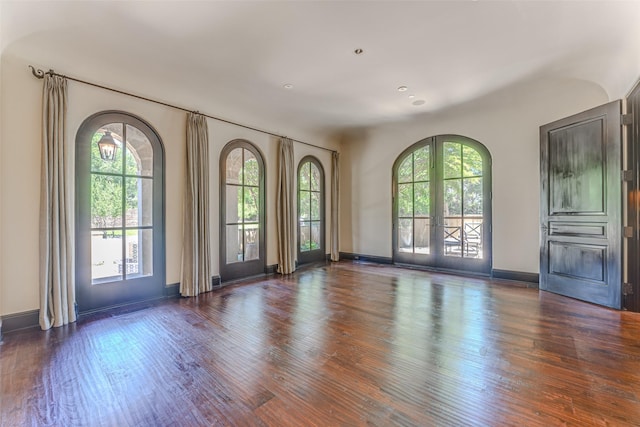 unfurnished living room with wood finished floors and baseboards