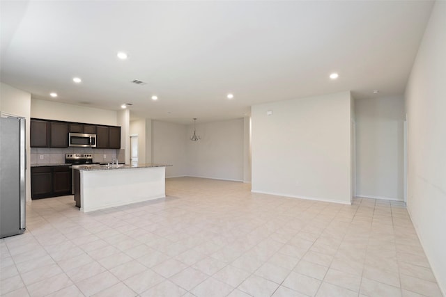 2302 Torch Lake Dr, Forney, TX 75126 - kitchen featuring appliances with stainless steel finishes, open floor plan, recessed lighting, a center island with sink, and backsplash