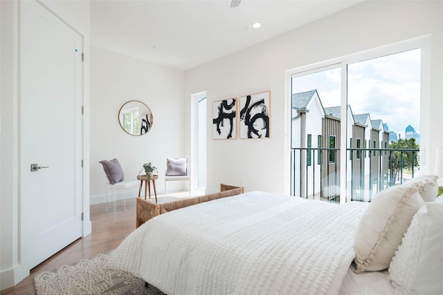 bedroom with wood finished floors, access to exterior, baseboards, and recessed lighting