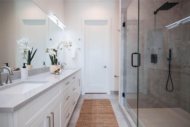 full bath with a stall shower, double vanity, and tile patterned flooring