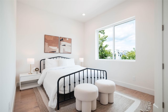 bedroom with wood finished floors, baseboards, and recessed lighting