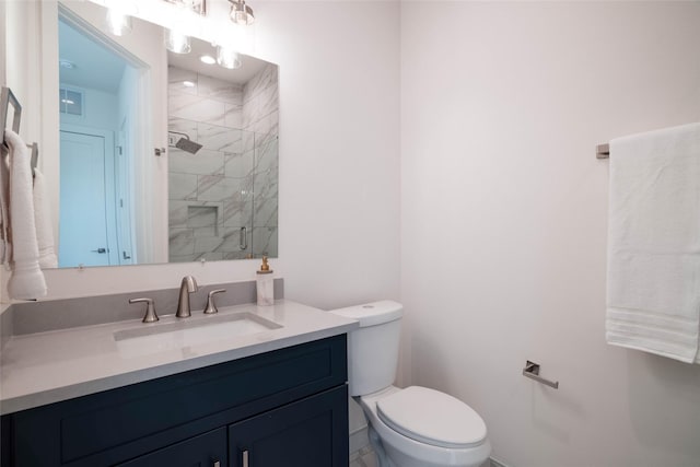 bathroom with a shower stall, toilet, and vanity