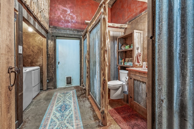 1545 County Road 130, Stephenville, TX 76401 - bathroom with washing machine and dryer, vanity, toilet, concrete flooring, and a towering ceiling