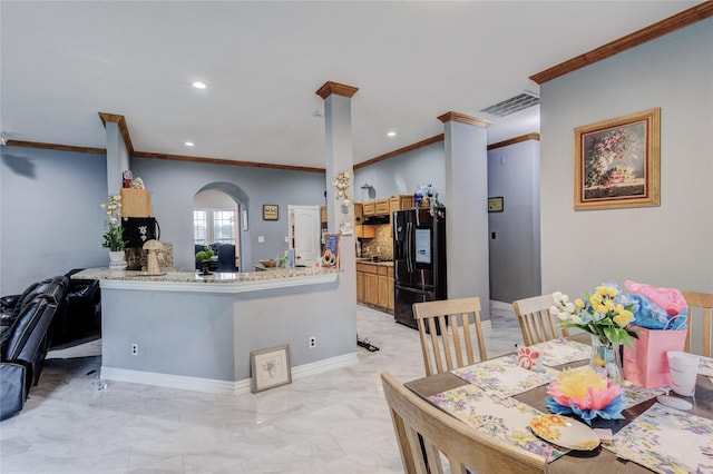 kitchen featuring black fridge with ice dispenser, crown molding, recessed lighting, light marble finish floors, and baseboards
