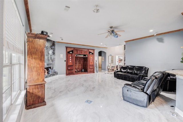 living area featuring arched walkways, ceiling fan, marble tiled flooring, crown molding, and recessed lighting