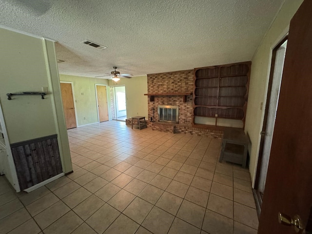 1946 US Highway 380 E, Graham, TX 76450 - unfurnished living room featuring tile patterned flooring, a fireplace, ceiling fan, and a textured ceiling