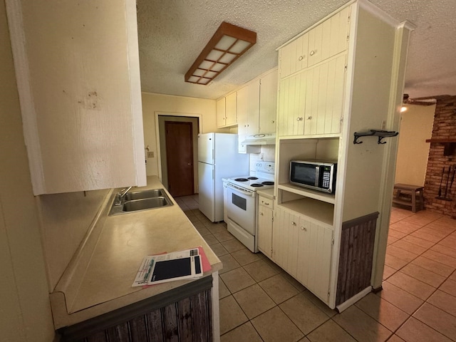 1946 US Highway 380 E, Graham, TX 76450 - kitchen featuring white appliances, under cabinet range hood, a textured ceiling, light tile patterned flooring, and a sink