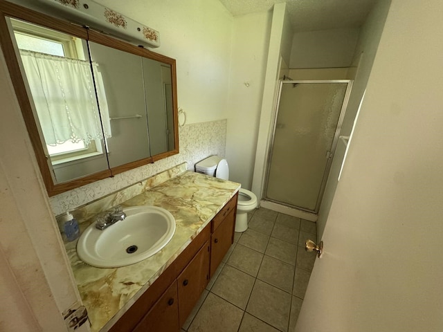 1946 US Highway 380 E, Graham, TX 76450 - full bathroom featuring a stall shower, toilet, vanity, and tile patterned floors