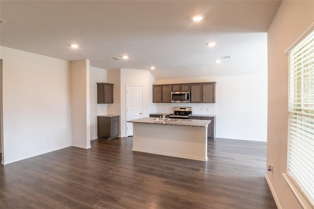 3929 Dickinson Ave, Aubrey, TX 76227 - kitchen with appliances with stainless steel finishes, a center island with sink, dark wood-style floors, light stone countertops, and baseboards