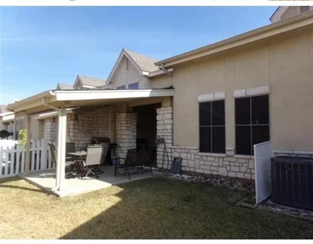 827 Kitty Hawk Ln, Grand Prairie, TX 75051 - rear view of house with a patio, central AC unit, stone siding, and stucco siding