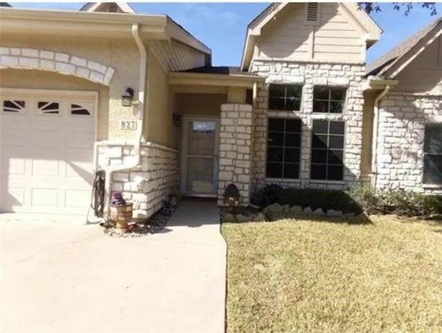 827 Kitty Hawk Ln, Grand Prairie, TX 75051 - entrance to property with stone siding, an attached garage, a lawn, and driveway