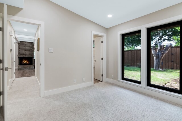 405 Martin Ln, Euless, TX 76040 - unfurnished room with light colored carpet, a stone fireplace, baseboards, recessed lighting, and lofted ceiling