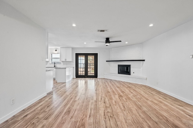 600 Circleview Dr N, Hurst, TX 76054 - unfurnished living room with french doors, recessed lighting, light wood-type flooring, baseboards, and a sink