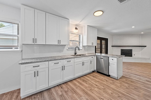 600 Circleview Dr N, Hurst, TX 76054 - kitchen with dishwasher, a sink, decorative backsplash, white cabinets, and a textured ceiling