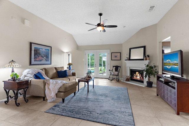 living area featuring vaulted ceiling, a ceiling fan, a textured ceiling, light tile patterned floors, and baseboards