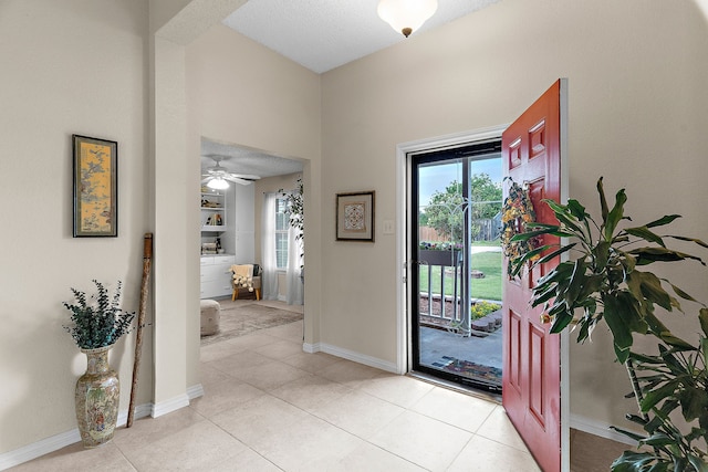 entryway featuring light tile patterned floors, baseboards, and a textured ceiling