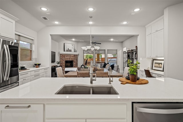 1429 Bridgewater Blvd, Celina, TX 75009 - kitchen with appliances with stainless steel finishes, open floor plan, recessed lighting, a fireplace, and decorative backsplash