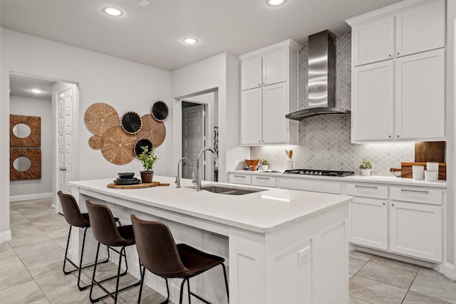 1429 Bridgewater Blvd, Celina, TX 75009 - kitchen featuring wall chimney range hood, a sink, a kitchen island with sink, gas stovetop, and tasteful backsplash