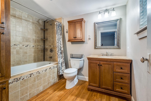 1009 W 7th St, Justin, TX 76247 - full bathroom featuring wood finished floors, tiled shower / bath, toilet, baseboards, and vanity