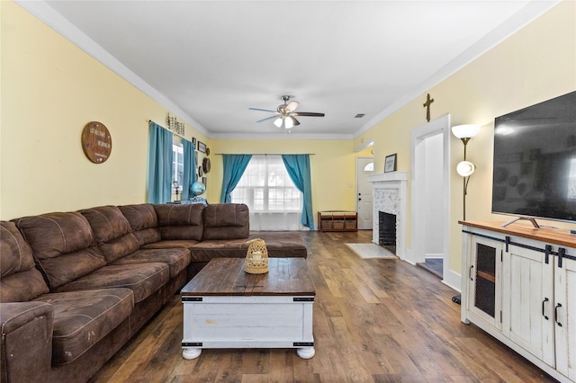 200 S Mimosa St, Paradise, TX 76073 - living room featuring ceiling fan, crown molding, dark wood-type flooring, a fireplace with flush hearth, and baseboards