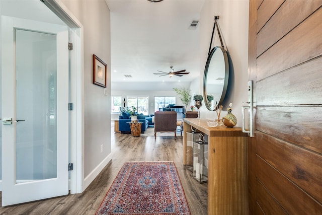 corridor with wood finished floors and baseboards