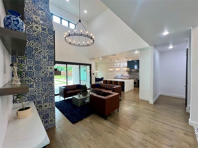 613 Wildcat Way, Kennedale, TX 76060 - living area featuring a high ceiling, a chandelier, light wood finished floors, healthy amount of natural light, and baseboards