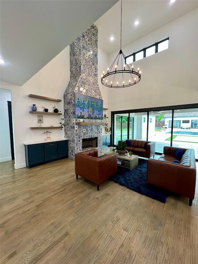 613 Wildcat Way, Kennedale, TX 76060 - living area featuring a towering ceiling, light wood finished floors, a chandelier, a fireplace, and recessed lighting