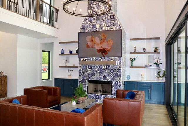 613 Wildcat Way, Kennedale, TX 76060 - living room with a fireplace, a chandelier, wood finished floors, built in shelves, and a towering ceiling