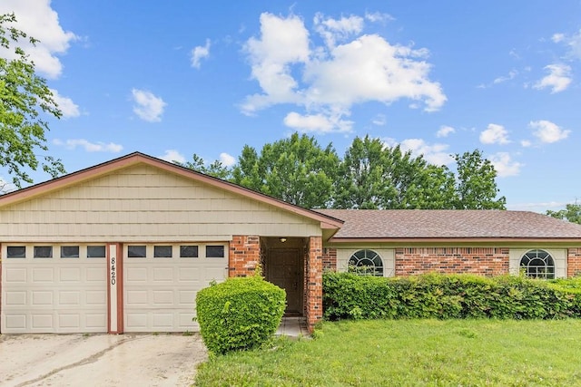 ranch-style home with brick siding, concrete driveway, a garage, a shingled roof, and a front yard