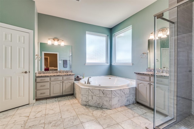 2401 Greenwich Dr, Carrollton, TX 75006 - bathroom with marble look tile flooring, a shower stall, a jetted tub, and vanity