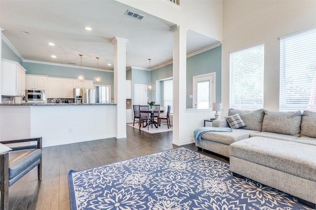 2401 Greenwich Dr, Carrollton, TX 75006 - living area with dark wood-style flooring, decorative columns, recessed lighting, crown molding, and baseboards
