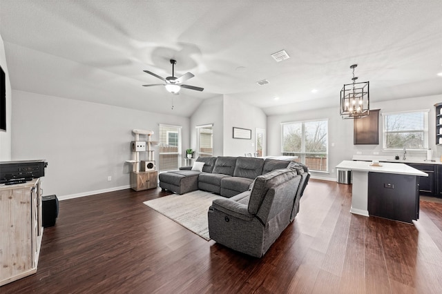 10116 Mickler Ln, Waco, TX 76708 - living room with dark wood-type flooring, ceiling fan, baseboards, vaulted ceiling, and a chandelier