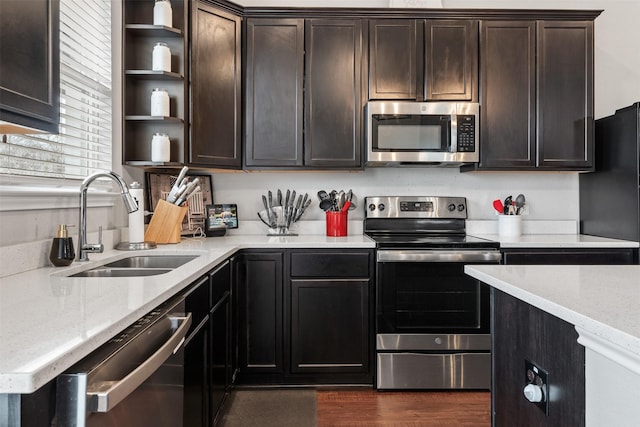 10116 Mickler Ln, Waco, TX 76708 - kitchen featuring appliances with stainless steel finishes, a sink, open shelves, dark brown cabinetry, and light stone counters