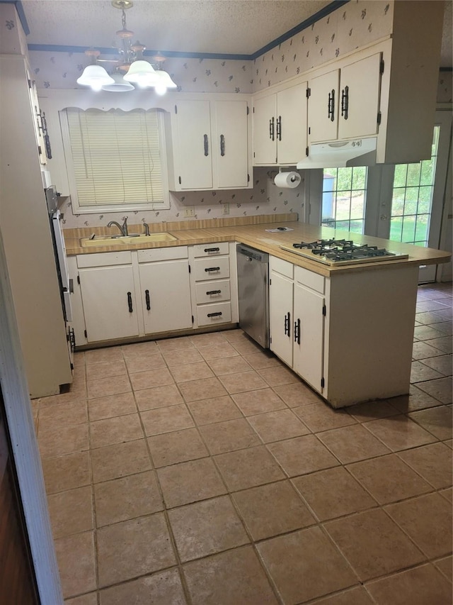 6313 Westwood Rd, Shreveport, LA 71129 - kitchen with stainless steel dishwasher, a sink, gas stovetop, under cabinet range hood, and a textured ceiling