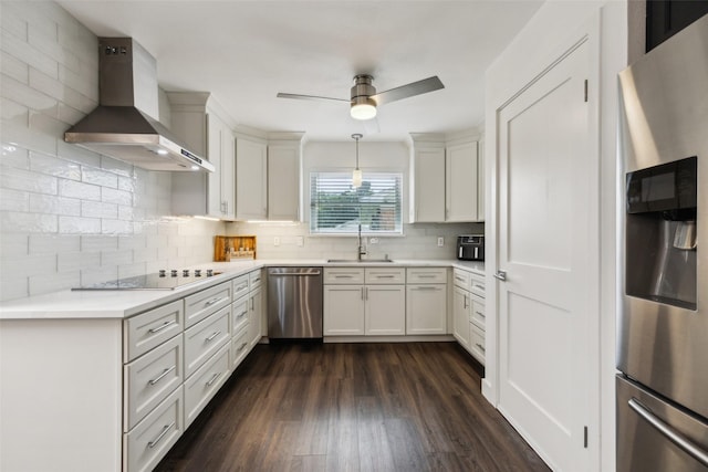 10834 Wyatt St, Dallas, TX 75218 - kitchen with stainless steel appliances, wall chimney range hood, a sink, dark wood-style floors, and decorative backsplash