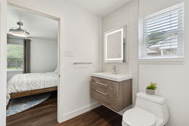 10834 Wyatt St, Dallas, TX 75218 - ensuite bathroom with wood finished floors, baseboards, toilet, and vanity