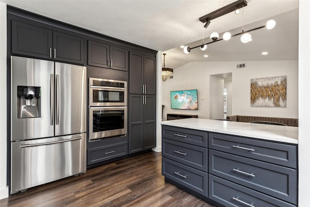 10834 Wyatt St, Dallas, TX 75218 - kitchen with appliances with stainless steel finishes, dark wood-style flooring, vaulted ceiling, a peninsula, and light stone counters