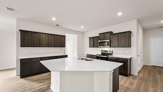 440 Drake Dr, Ferris, TX 75125 - kitchen with stainless steel microwave, electric stove, light wood finished floors, light countertops, and recessed lighting