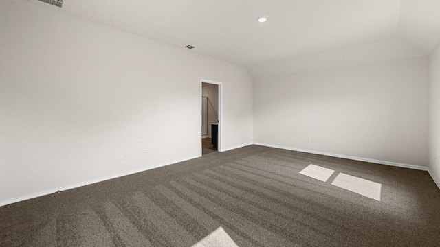 440 Drake Dr, Ferris, TX 75125 - empty room with dark carpet, lofted ceiling, and recessed lighting