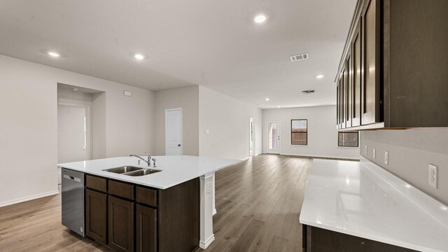 440 Drake Dr, Ferris, TX 75125 - kitchen with stainless steel dishwasher, dark brown cabinetry, light wood-type flooring, recessed lighting, and a kitchen island with sink