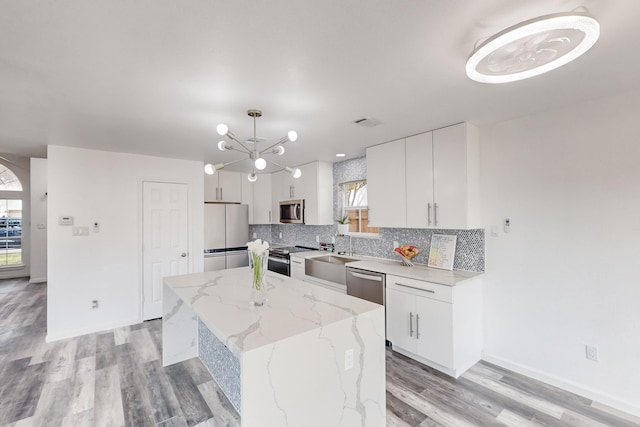 827 Astaire Ave, Duncanville, TX 75137 - kitchen with stainless steel appliances, tasteful backsplash, light wood-type flooring, and white cabinetry
