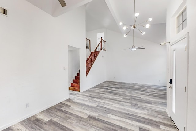 827 Astaire Ave, Duncanville, TX 75137 - unfurnished living room featuring ceiling fan, a chandelier, high vaulted ceiling, stairway, and light wood-type flooring