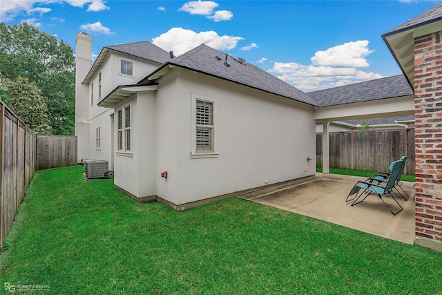 rear view of house with central AC, a patio area, roof with shingles, a chimney, and stucco siding