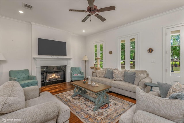 living room with wood finished floors, crown molding, ceiling fan, a high end fireplace, and recessed lighting