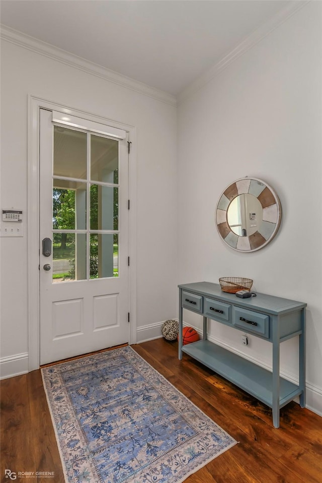 doorway with crown molding, dark wood finished floors, and baseboards